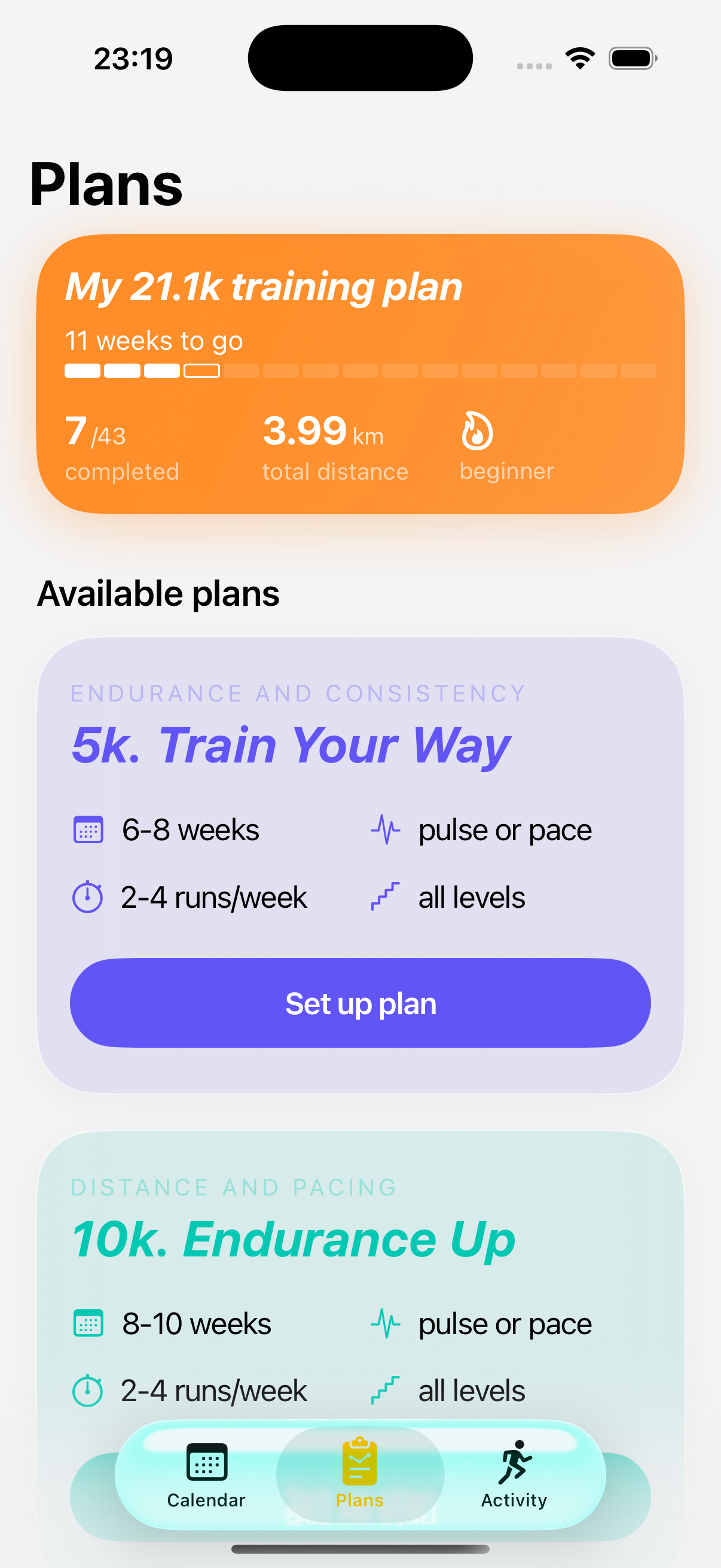 The same Plans tab on iOS 26, light mode — the active "My 21.1k training plan" card sits in a soft orange gradient with a translucent edge, the "5K. Train Your Way" card below it is a glass-tinted purple panel, and the tab bar at the bottom is a single glass pill with a yellow Plans icon highlighted.